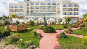 A hotel with a central courtyard, multiple balconies, and outdoor seating areas. - Therma Palace - Hotel & SPA (Kranevo)