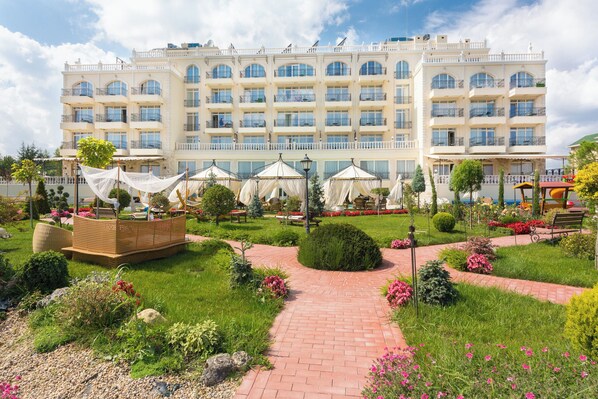 A hotel with a central courtyard, multiple balconies, and outdoor seating areas. - Therma Palace - Hotel & SPA (Kranevo)