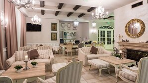 A cozy, well-lit lounge area with comfortable seating, a fireplace, and decorative lighting. - Therma Palace - Hotel & SPA (Kranevo)