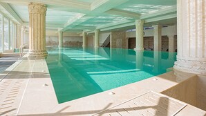 A large indoor swimming pool with classical columns, a tiled floor, and a high ceiling. - Therma Palace - Hotel & SPA (Kranevo)