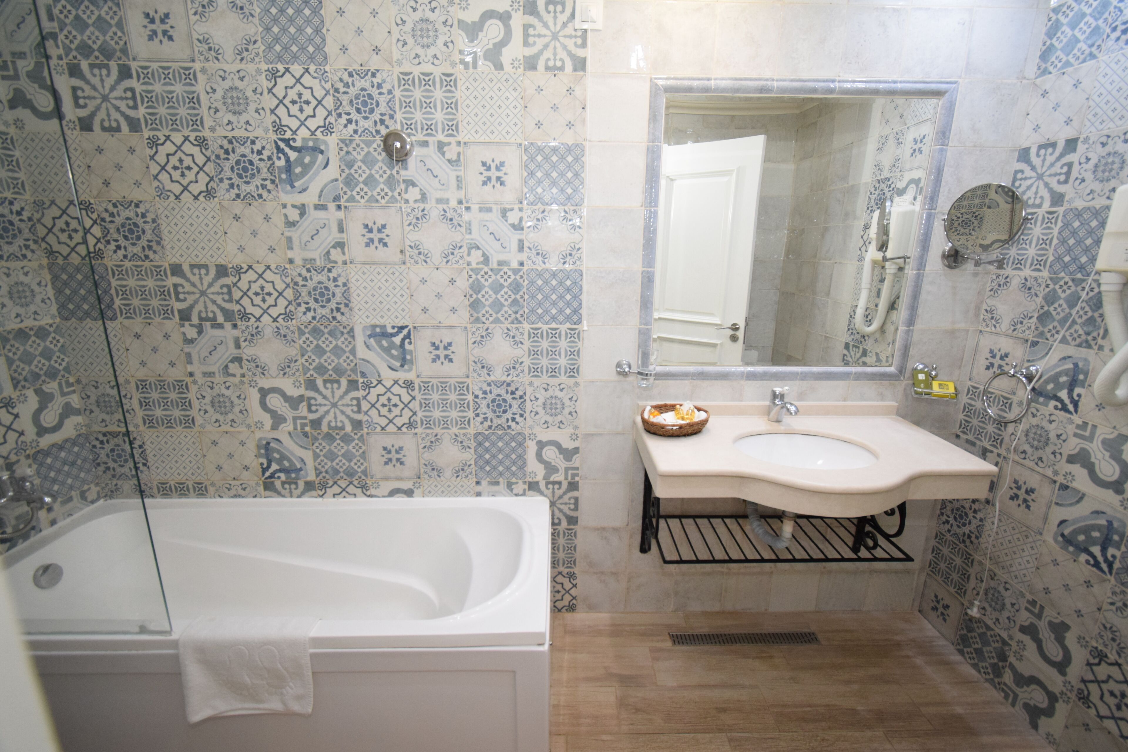 A bathroom with a bathtub, sink, and mirror.
