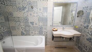 A bathroom with a bathtub, sink, and mirror.