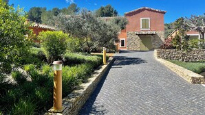 A paved pathway leading to a building with a red facade and stone accents. - Chambre d'hôtes with swimming pool, jacuzzi, sauna and working in the vineyards  (La Cadière-d'Azur)