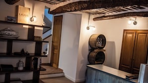 A modern interior with a wooden staircase, a reception desk, and a wall-mounted wine barrel. - Chambre d'hôtes with swimming pool, jacuzzi, sauna and working in the vineyards  (La Cadière-d'Azur)