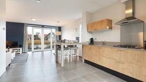 A modern kitchen with a central island, wooden cabinets, and a stainless steel range hood.