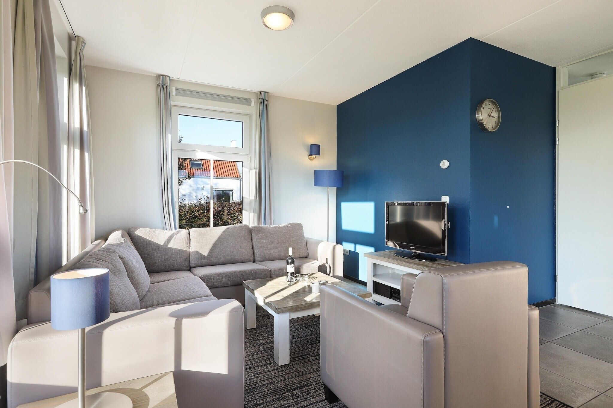 A modern living room with a sofa, coffee table, and TV.