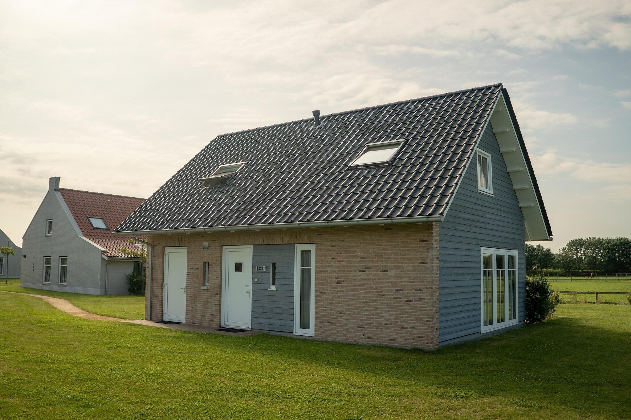 Ein eingeschossiges Haus mit geneigtem Dach, einer Haustür und einem kleinen Fenster.