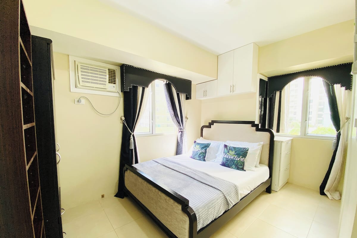 Un dormitorio con cama, armario y ventana.