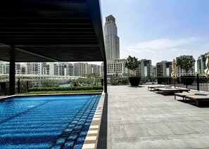 A rooftop swimming pool with a view of high-rise buildings.