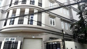 A multi-story building with balconies and a garage. - Hoang Nam Hotel Q2 SG- by Bay Luxury (Ho Chi Minh City)