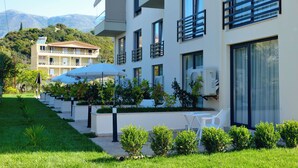 A modern hotel with multiple balconies, outdoor seating, and a well-maintained garden. - The Blue Wave Hotel (Himarë)