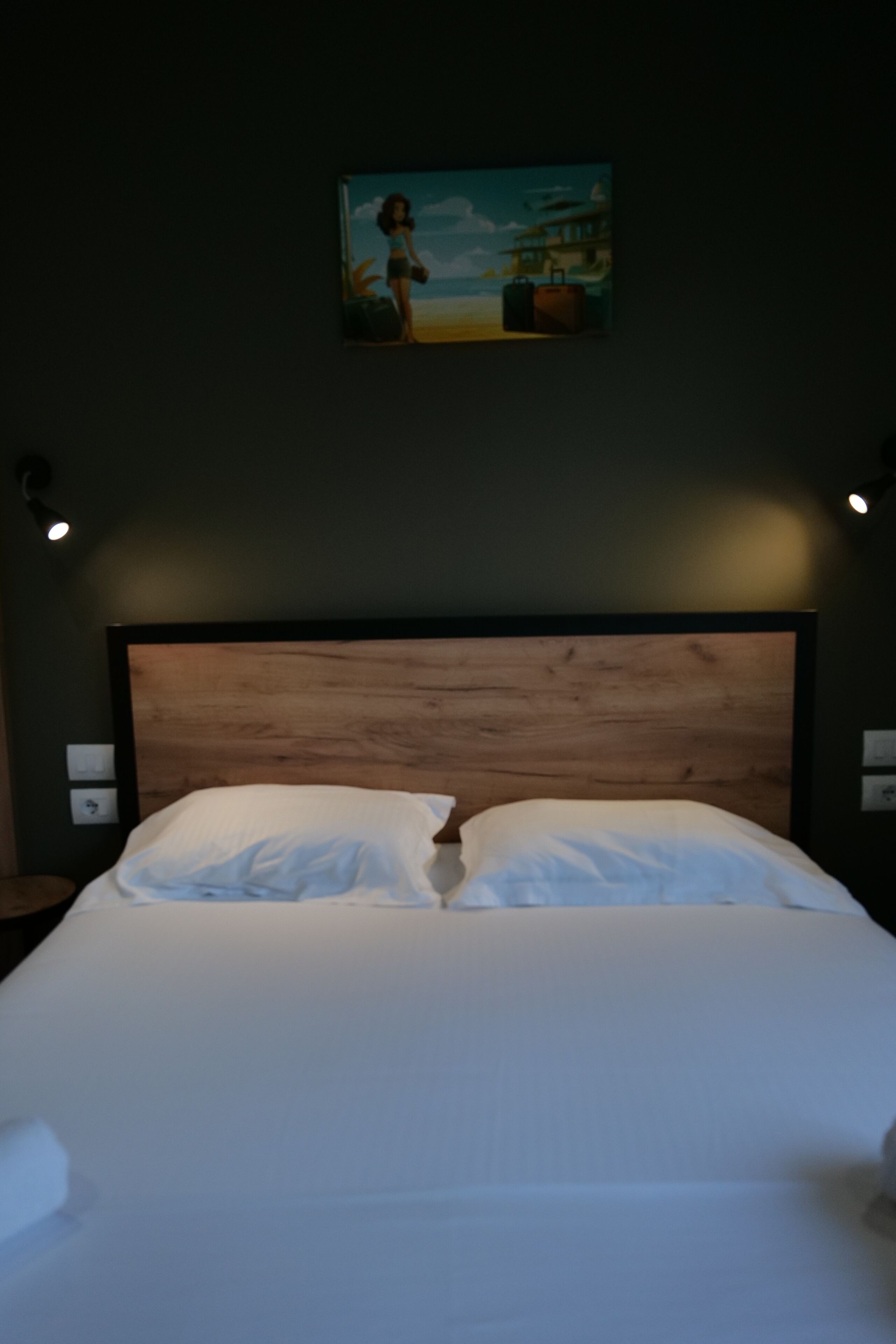 A neatly made bed with white linens in a room with a wooden headboard.