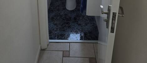 A small, compact bathroom with a toilet, a sink, and a window.