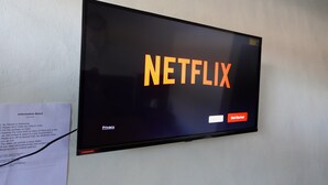 A television screen displaying the Netflix logo with a "Get Started" button. - Pondok Dete Guesthouse (Denpasar)
