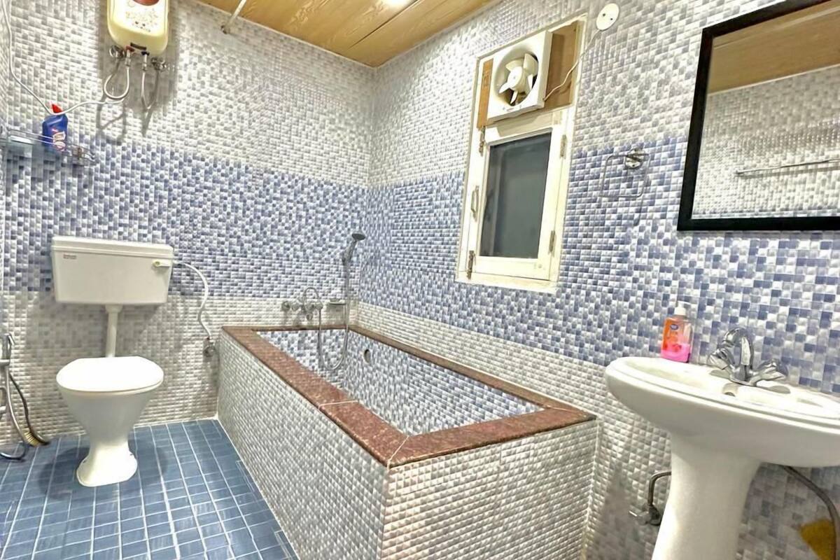 Ein Badezimmer mit Badewanne, Toilette und Waschbecken, komplett mit blauen und weißen Fliesen.