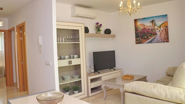 A modern living room with a TV, sofa, and decorative items. - Apartamento El Mirador (Conil de la Fra.)