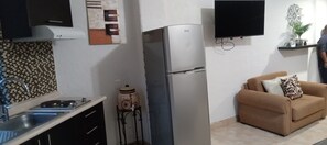 A kitchen with a refrigerator, a sink, and a tiled backsplash. - María Elena (Cabo San Lucas)