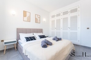 A modern bedroom with a bed, bedside tables, and a wardrobe. - 2bed beach apartment , first line lux with parking REF065 (Benalmádena)