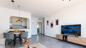 Enjoy a spacious living area with a dining table, kitchen island, and flat-screen TV.