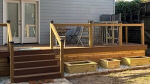 A house with a wooden deck, a set of stairs leading to a door, and a fenced backyard. - “Lovely” Bungalow near downtown Quincy!  (Quincy)