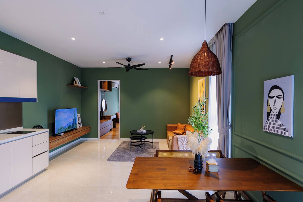 Un salon moderne avec une table à manger en bois, un téléviseur et un ventilateur de plafond.