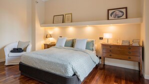 A bedroom with a bed, bedside tables, a chair, a dresser, and wall-mounted lamps. - Stunning  villa for 6 people with A/C, WIFI, TV and terrace (Nepi)