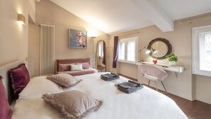 A bedroom with a bed, a desk, a chair, a radiator, a mirror, and a window. - BnButler - Pontaccio, 4 with terrace (Milano)