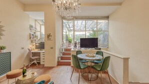 A modern living space with a dining area, a workspace, and a large window with a view of greenery. - BnButler - Pontaccio, 4 with terrace (Milano)