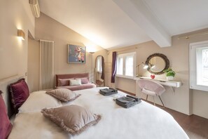 Une chambre à coucher avec un lit, un bureau, une chaise, un radiateur, un miroir et une fenêtre.