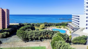 Un complexe hôtelier doté d’une piscine, d’une végétation luxuriante et offrant une vue sur l’océan.