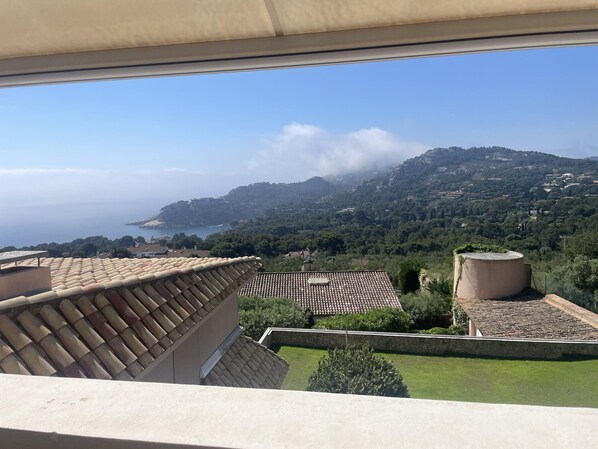 Une terrasse avec vue sur la mer et les collines.