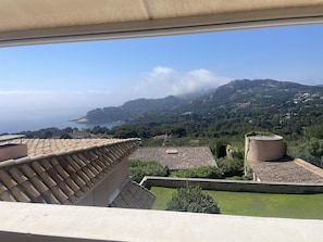 A terrace with a view of the sea and hills.