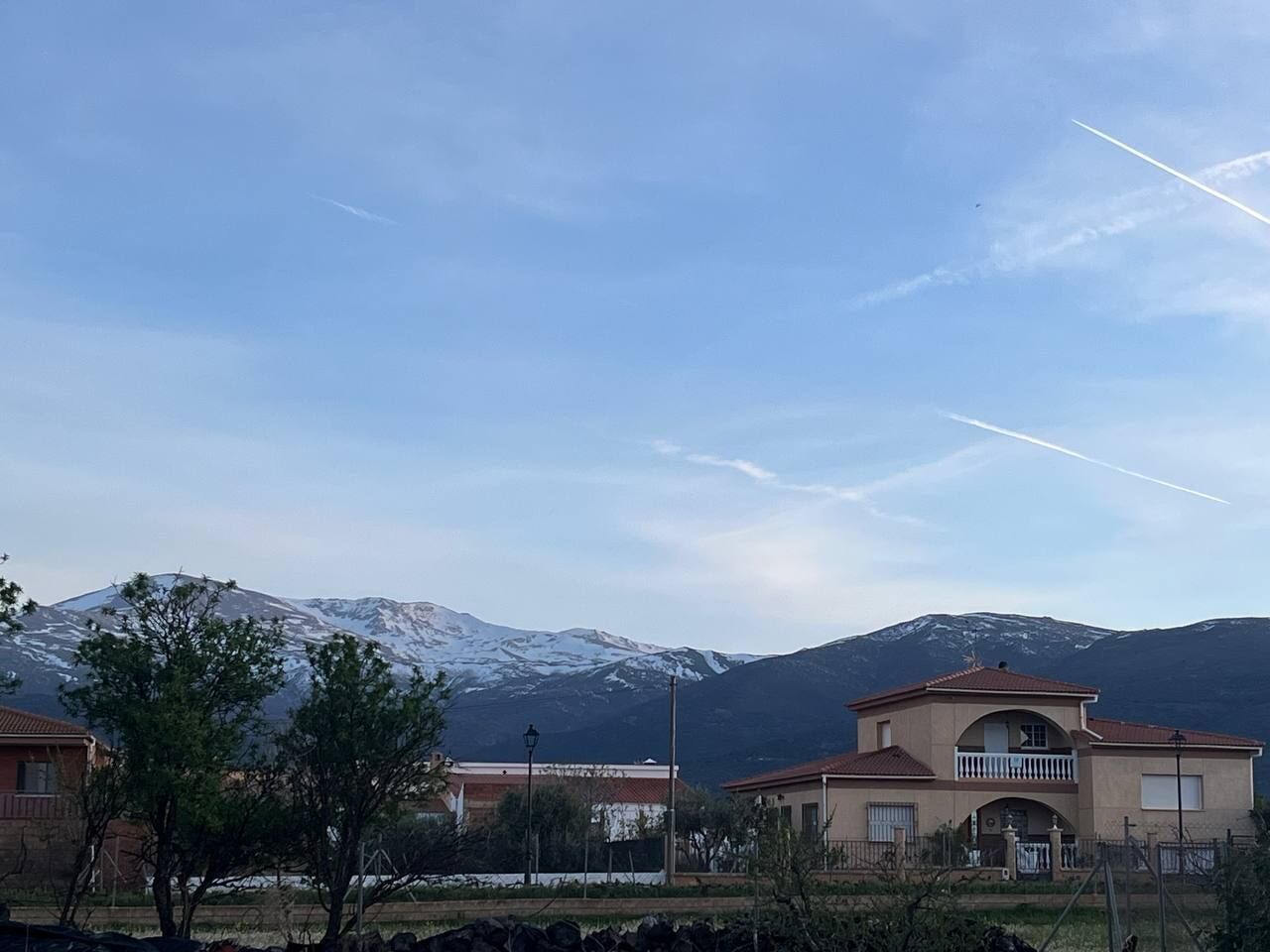Zona residencial con casas, una montaña al fondo y cielo despejado.
