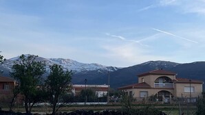 Un quartier résidentiel avec des maisons, une montagne en arrière-plan et un ciel dégagé.