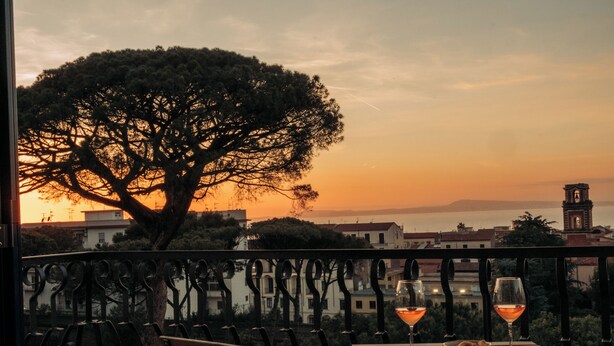 A balcony with a table, two glasses of wine, and a bowl of lemons. - Mermaids' Dream Sorrento (Sorrento)