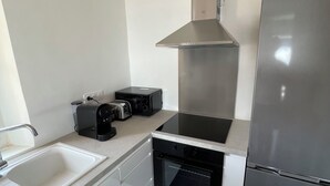 Una cocina moderna con campana de acero inoxidable, horno empotrado, refrigerador y lavavajillas.