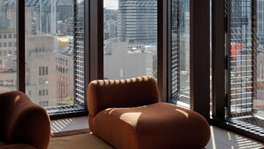 Un interior moderno con ventanas amplias, un sofá y una lámpara colgante.