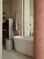A modern bathroom with a freestanding bathtub, a wooden vanity, and a towel hanging on the wall.