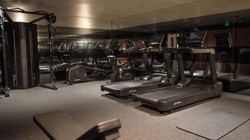A gym with treadmills, elliptical machines, and weightlifting equipment.