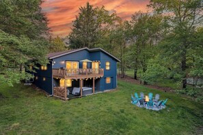 A two-story house with a balcony, surrounded by trees. - Creekside Playhouse | Hot Tub, Arcade, Beach, Pool (Albrightsville)