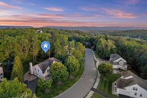 Un quartier résidentiel avec des maisons, une route sinueuse et une icône indiquant un emplacement.