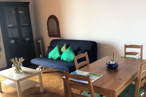 Relax in this inviting living room with a sofa, dining table, and chairs.