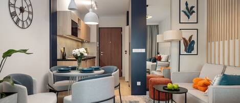 Una habitación de hotel moderna con comedor, sofá y cama.