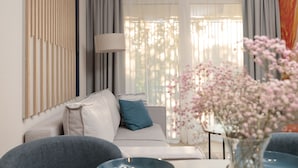 A modern living room with a sofa, a side table, and a vase of flowers.