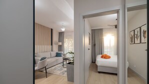 A modern hotel room with a sofa, a small table, and a bed.