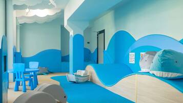 A children's play area with blue and white furniture, including a slide and a boat-shaped play structure.