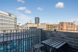A rooftop terrace with a view of the city skyline, including modern buildings and a distinctive cylindrical structure. - Beautiful, modern, light flat in Shoreditch (a) (Greater London)