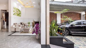 Un salon moderne avec un ensemble de canapés, une cheminée et des plantes décoratives.