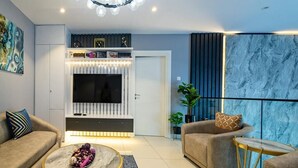 A modern living room with a flat-screen TV, two sofas, a coffee table, and a decorative wall. - EBS LEGEND GHANA  (Accra)