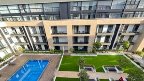 A modern apartment building with a swimming pool, green lawns, and outdoor seating areas. - EBS LEGEND GHANA  (Accra)